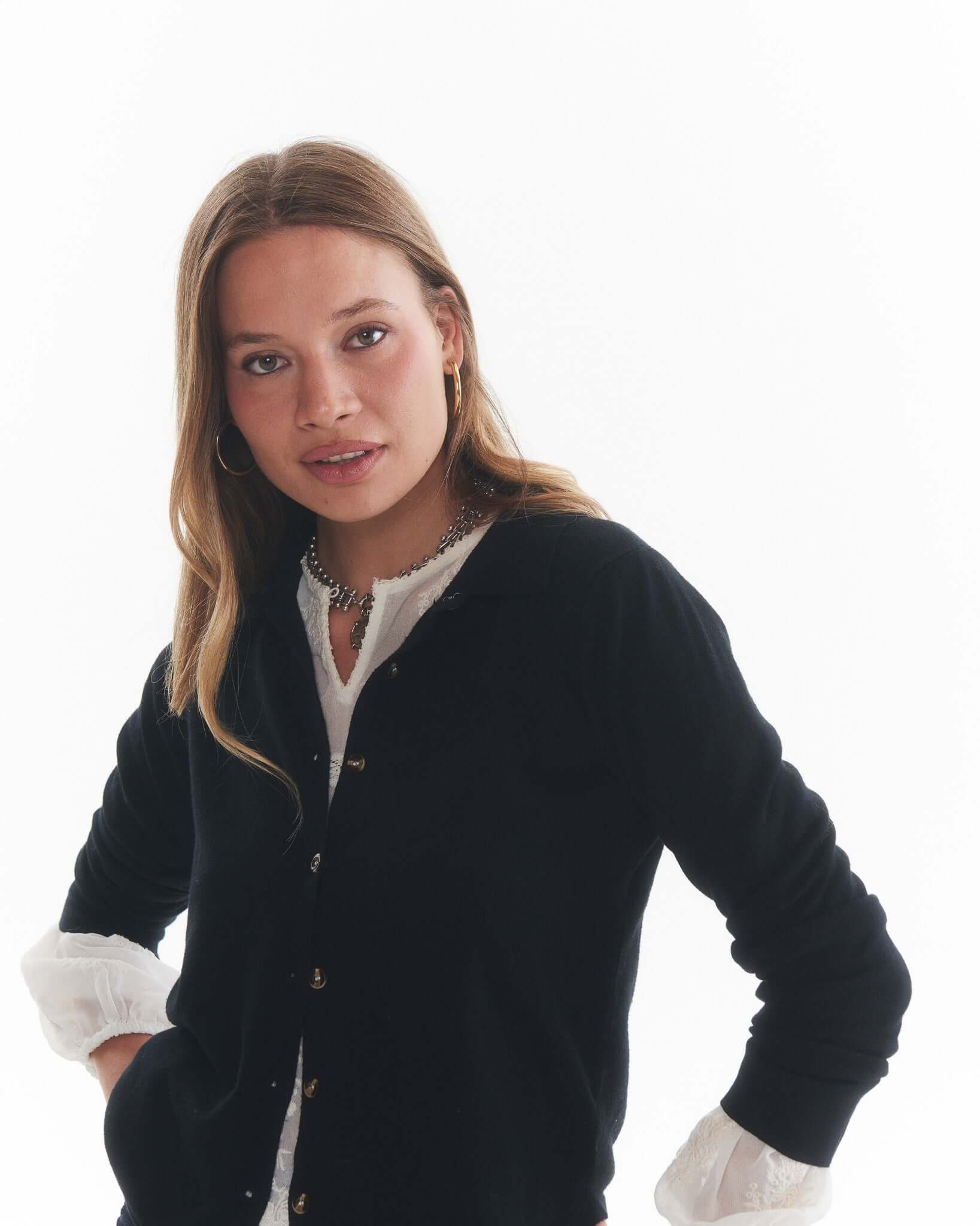Mujer con chaleco negro Lilo de cashmere, luciendo un estilo moderno y elegante, fondo blanco